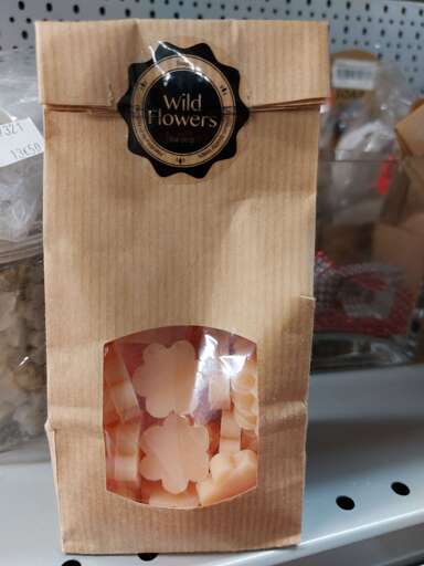 Un sachet de petits savons en forme de fleurs roses qu'on a l'impression de pouvoir manger.
Le sachet est fermé par une étiquette avec en grand "Wild Flowers", et en tout petit, "Soap"