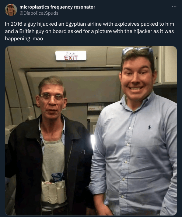 Tweet: "In 2016 a guy hijacked an Egyptian airline with explosives packed to him and a British guy on board asked for a picture with the hijacker as it was happening lmao" with a picture of a man with a suicide vest next to a smiling man. 