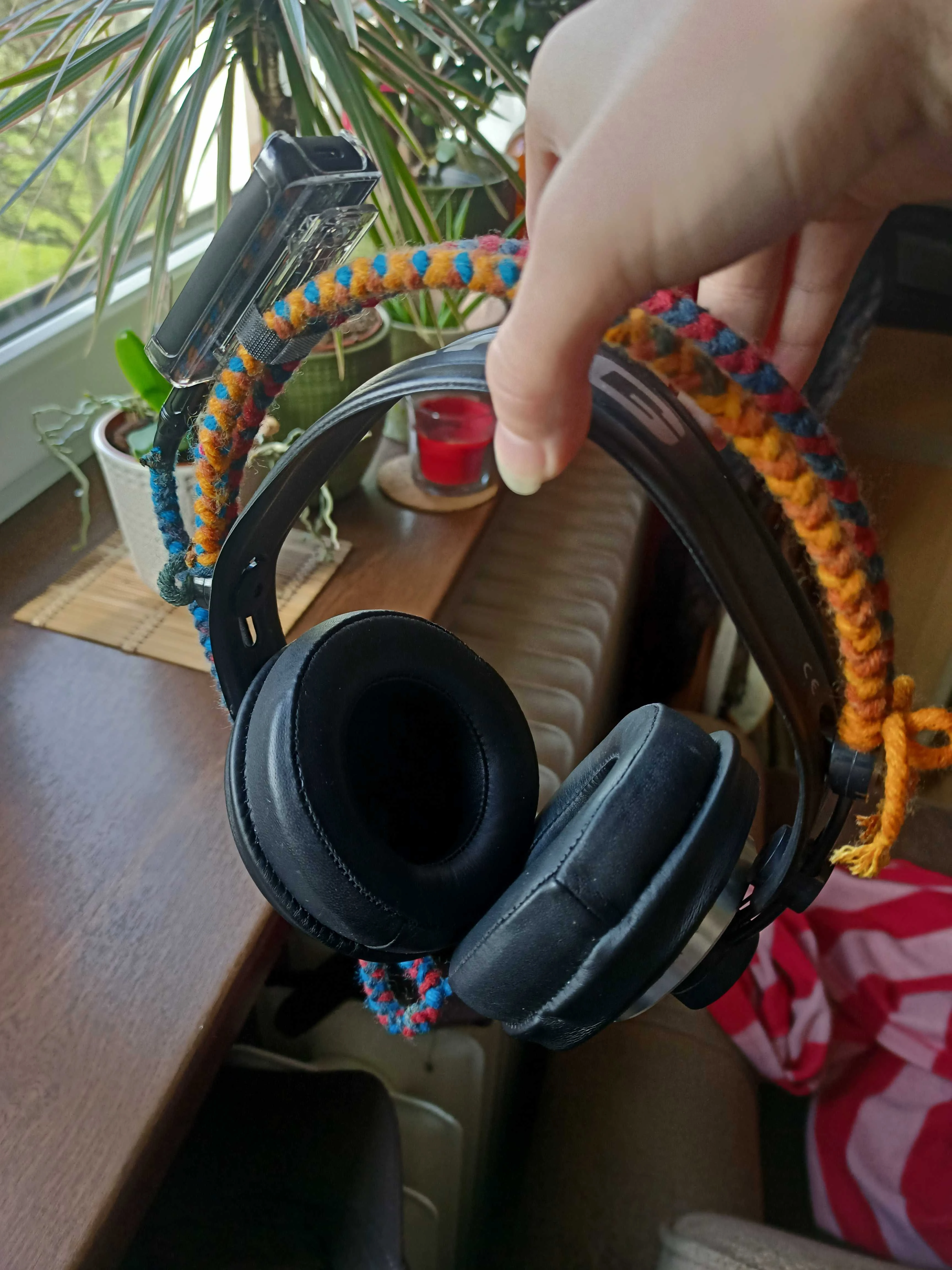 A pair of AKG k240 heaphones with the FiiO BTR5 strapped to one side. The headband wires are braided.